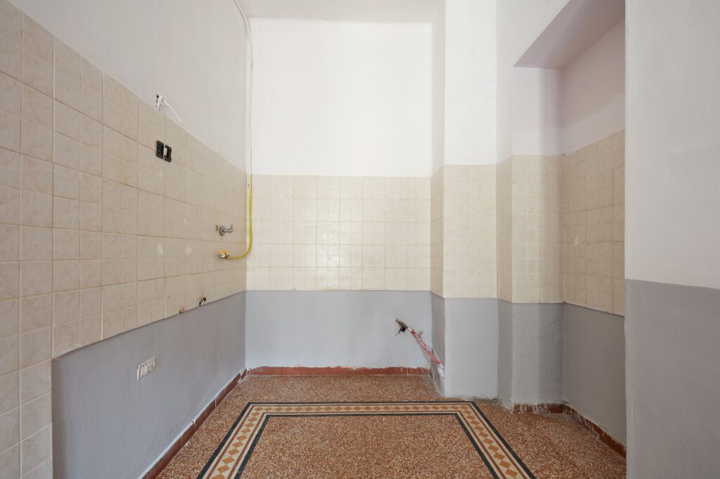 Empty kitchen interior with tiled floor and wall